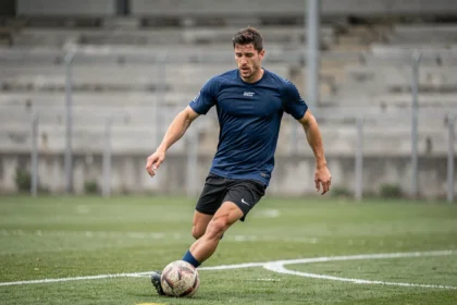 Joueur de football professionnel en entraînement sur un terrain gazonné, illustrant la question du club actuel d'Eden Hazard en 2026